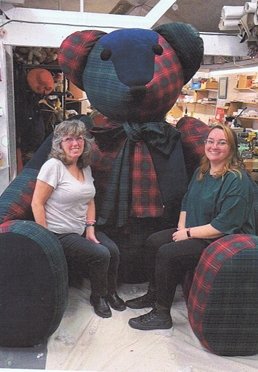 Members enjoying a trip with a large teddy bear display
